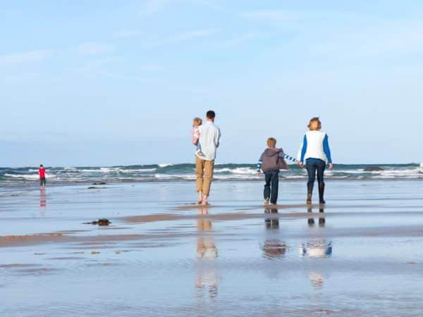 Family walking on Mawgan Porth Beach