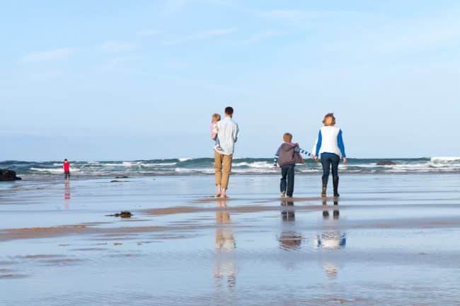 Family walking on Mawgan Porth Beach