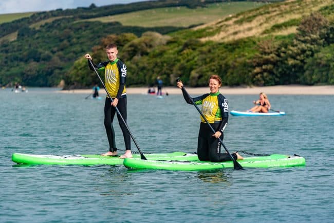 Mother and Son on Paddle boards in water